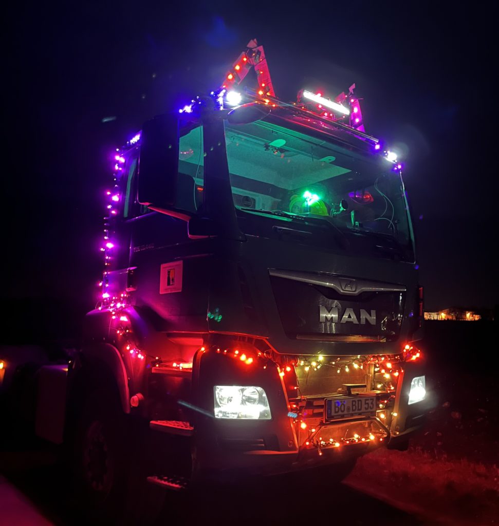LKW mit vielen bunten Lichterketten und Ohren